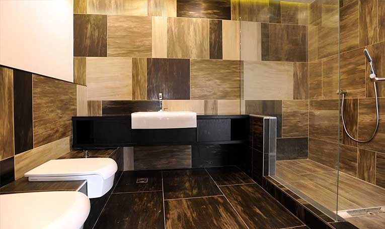 Bathroom with geometric stone wall tiles and a dark vanity