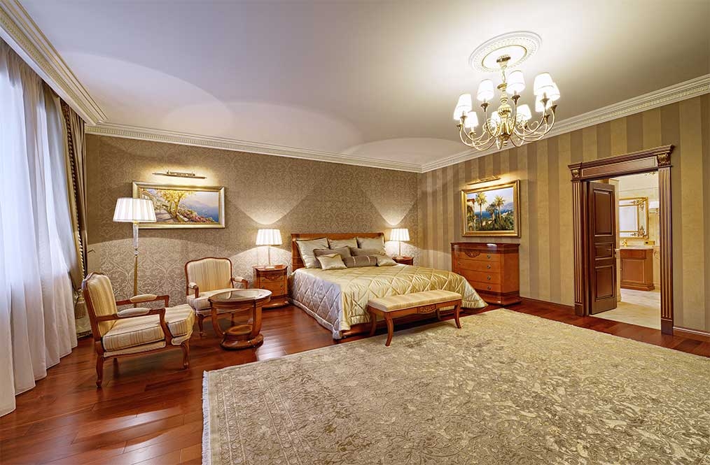 Spacious bedroom suite with a seating area and traditional timber furniture