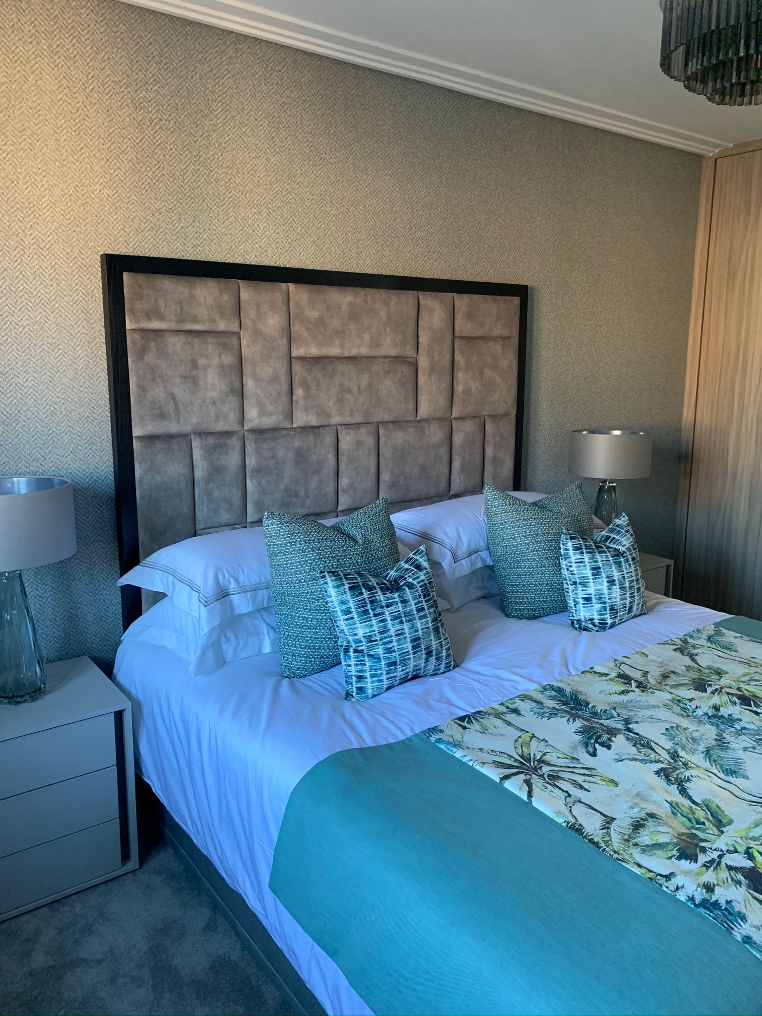 Bedroom with a tall upholstered headboard and coordinated blue cushions