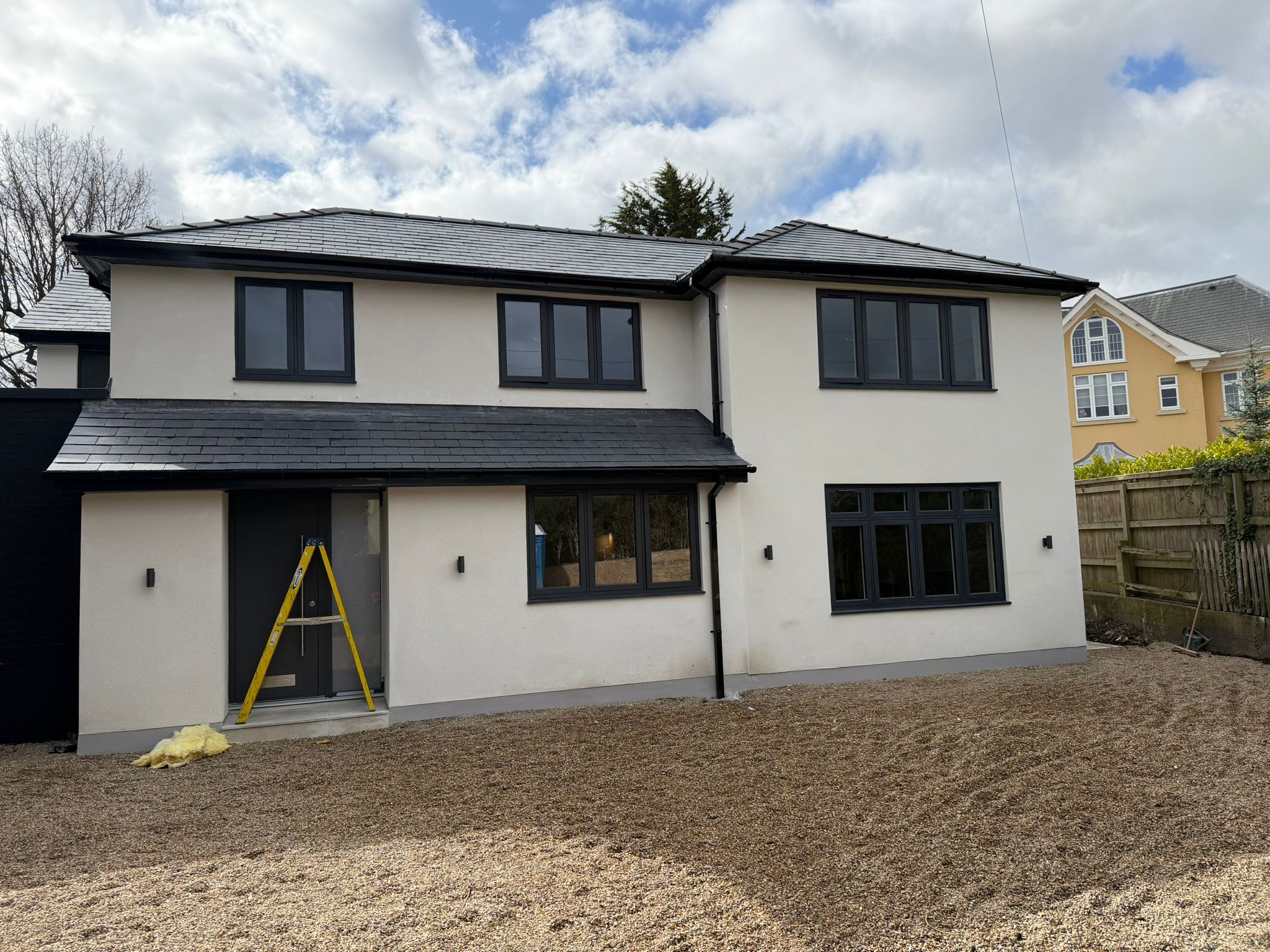 Completed two-storey rendered home with dark-framed windows
