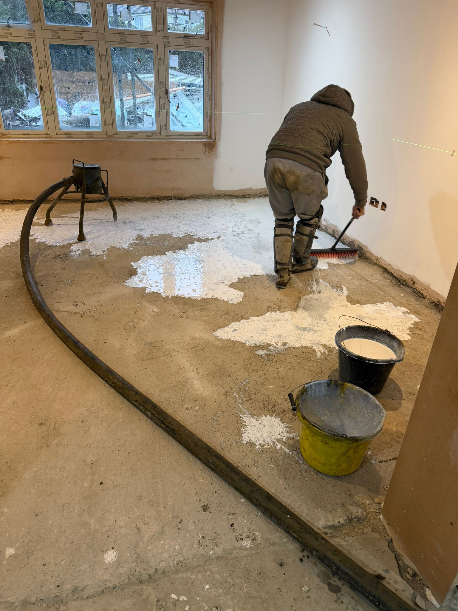 Floor screed being levelled during an interior renovation
