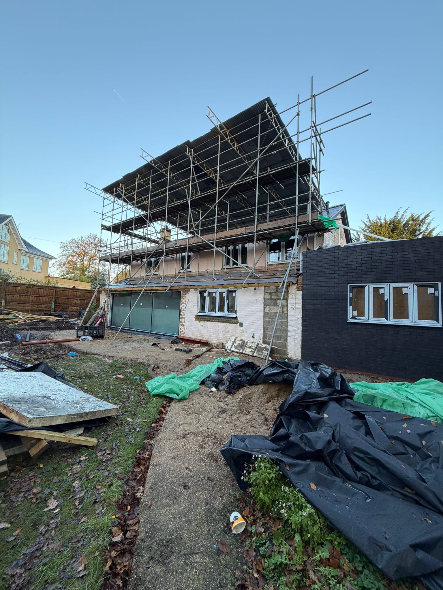 House renovation underway behind full-height exterior scaffolding