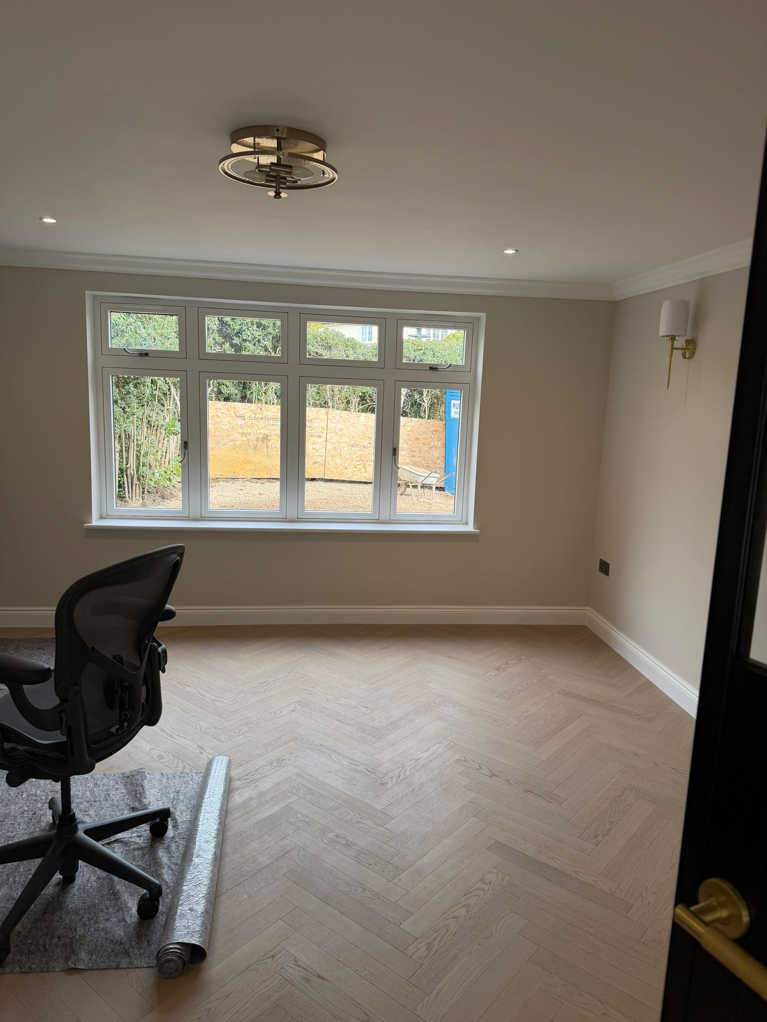Pale herringbone floor in a completed living room