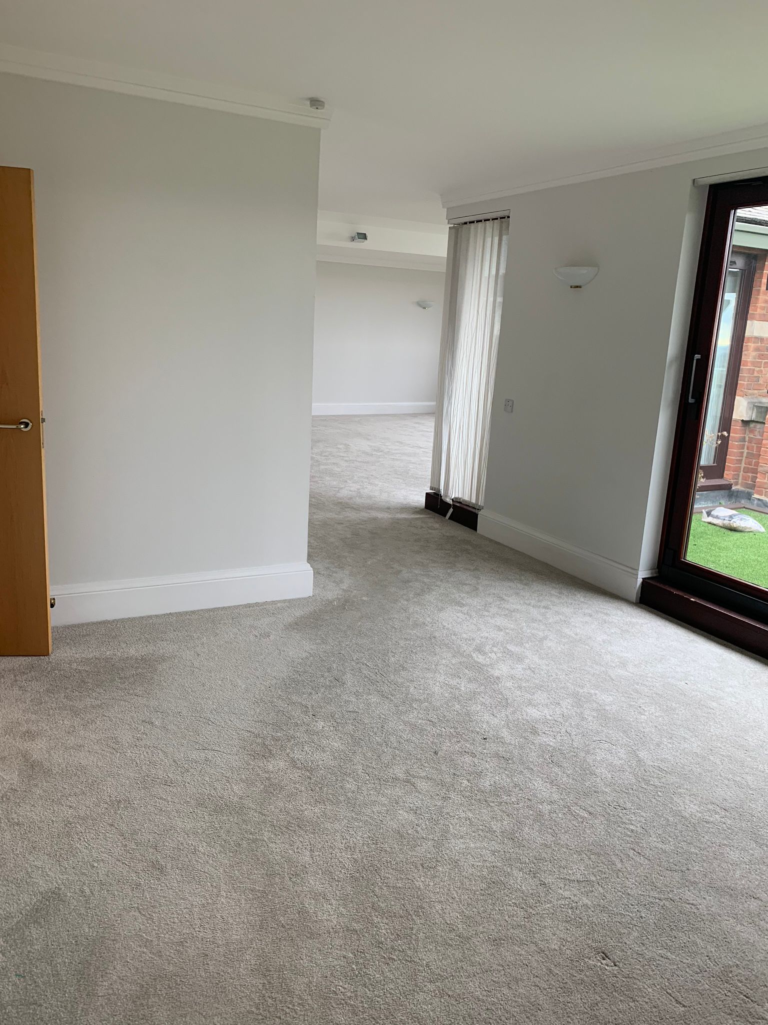 Soft grey carpet fitted through a bright living space