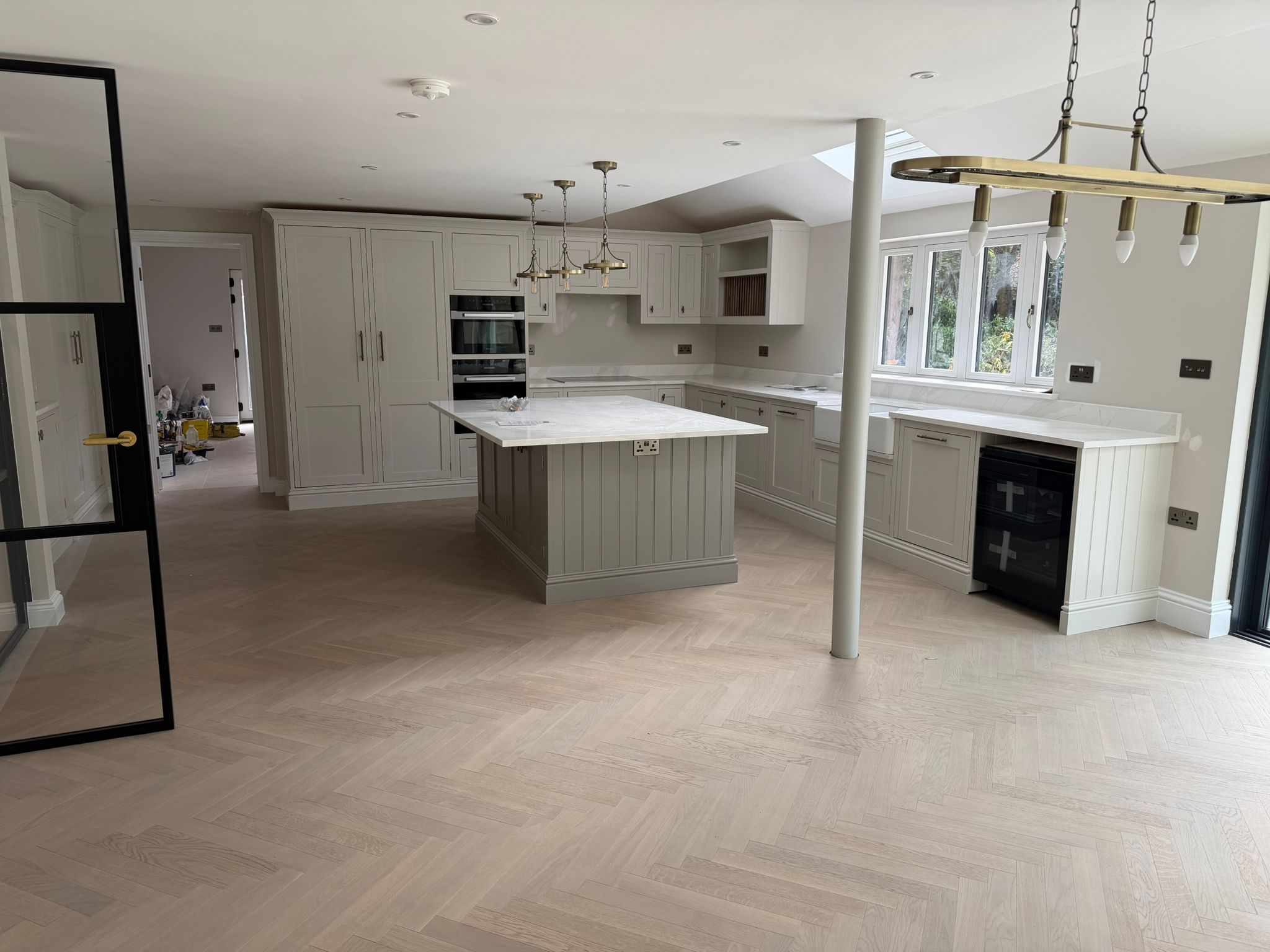 Open-plan kitchen fitted with pale cabinetry and a central island