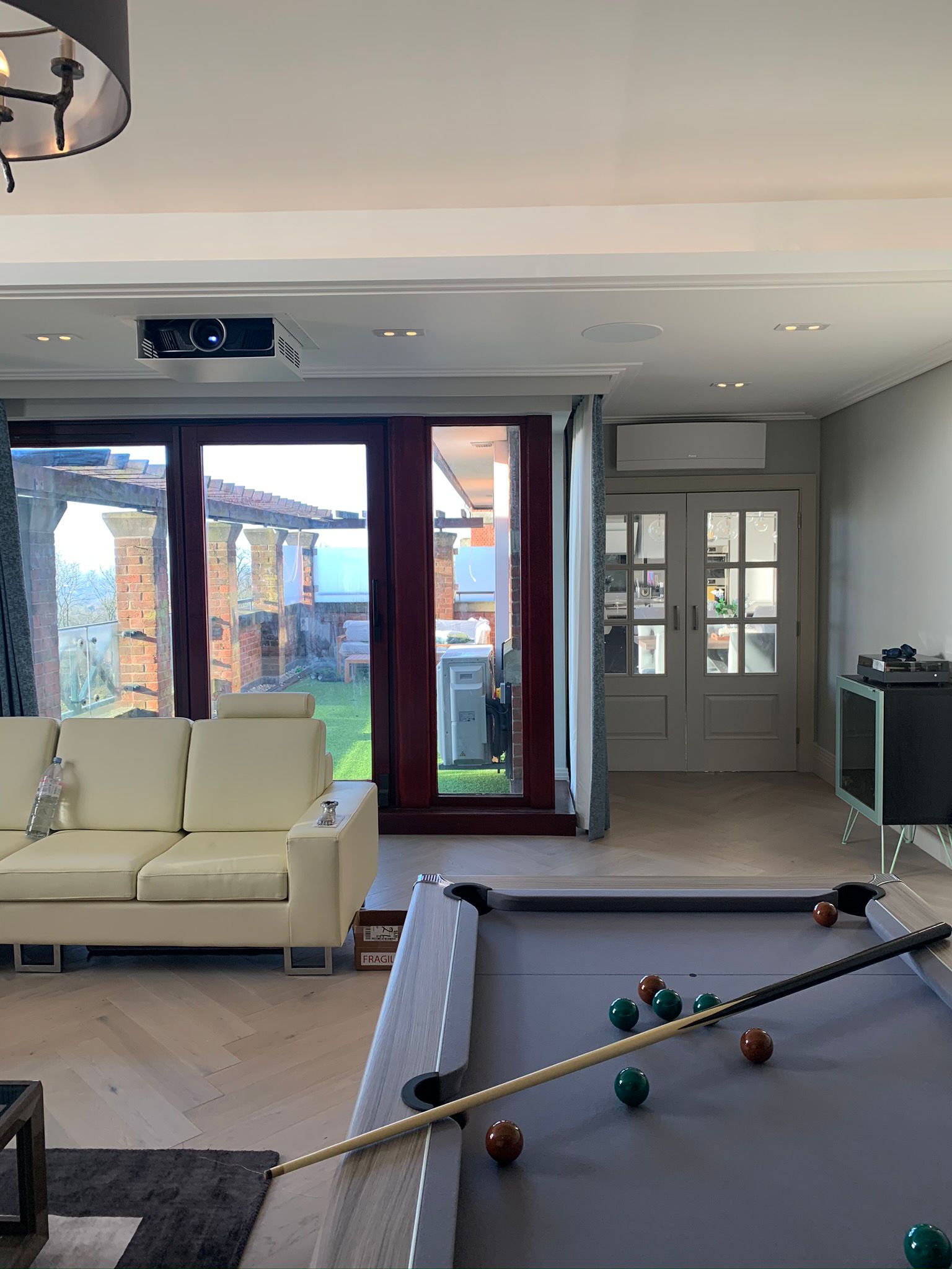 Furnished family room facing glazed garden doors and built-in cabinetry