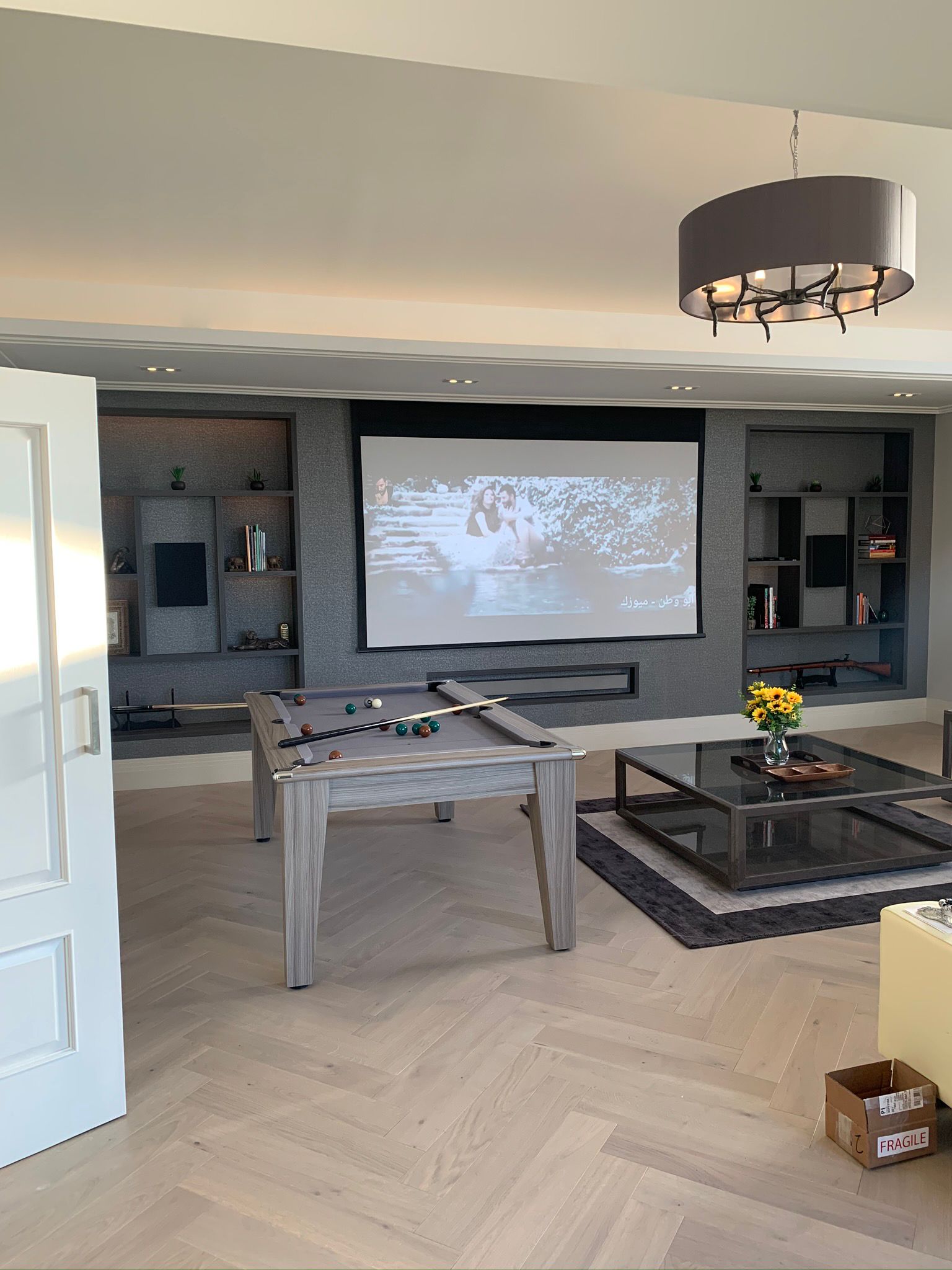 Games room with pool table, projector screen, and fitted media wall