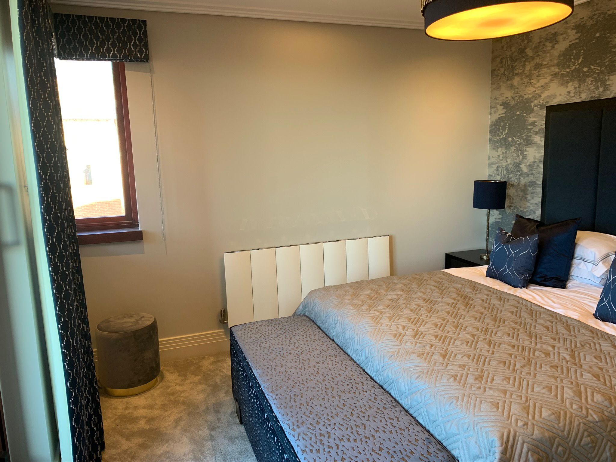 Finished bedroom with upholstered headboard and coordinated textiles
