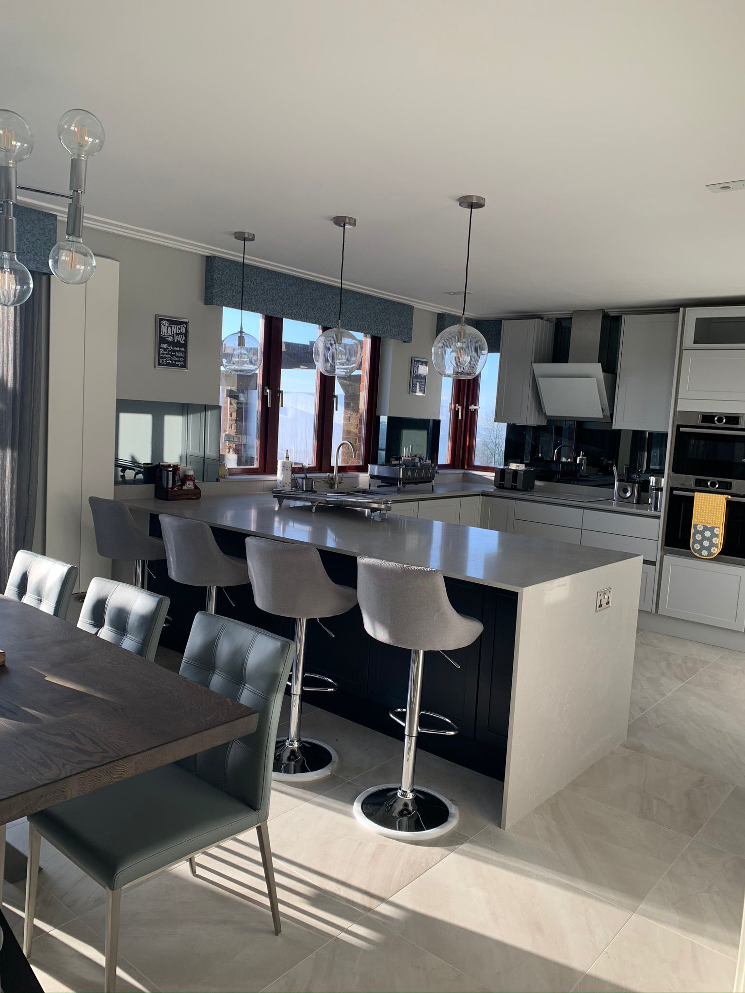 Open-plan kitchen and dining room with island seating and fitted appliances