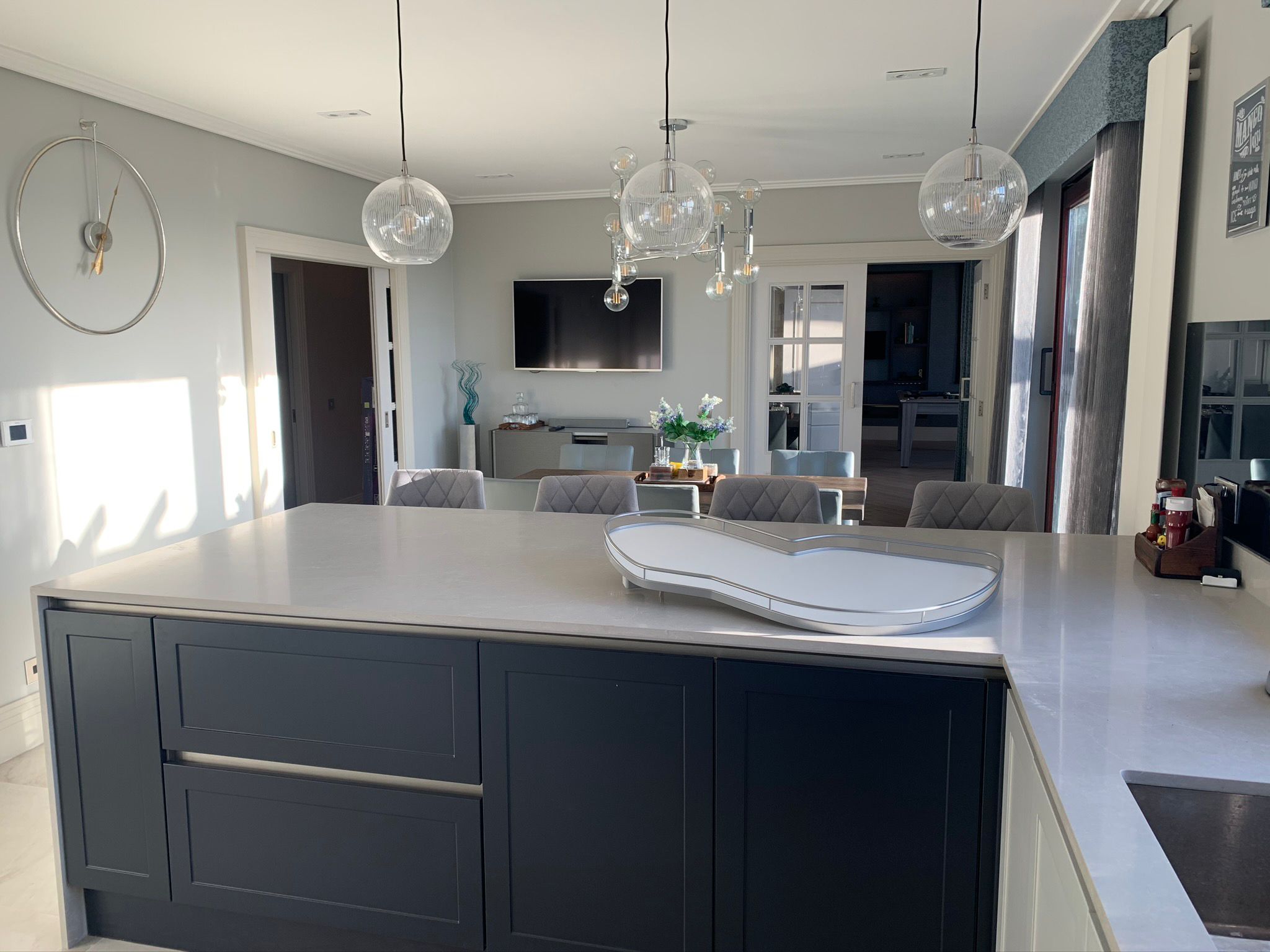Grey kitchen island with pale worktop and glass pendant lights