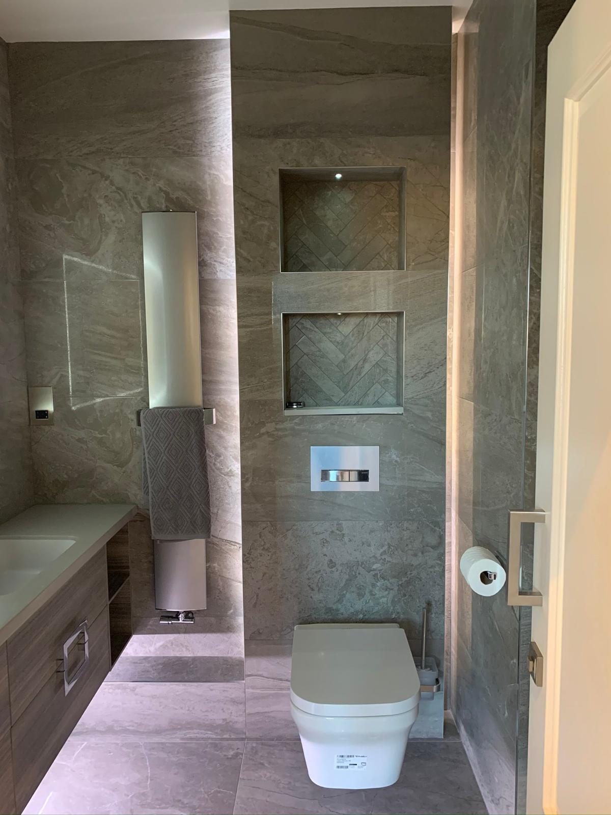 Compact cloakroom finished with a veined stone vanity surface
