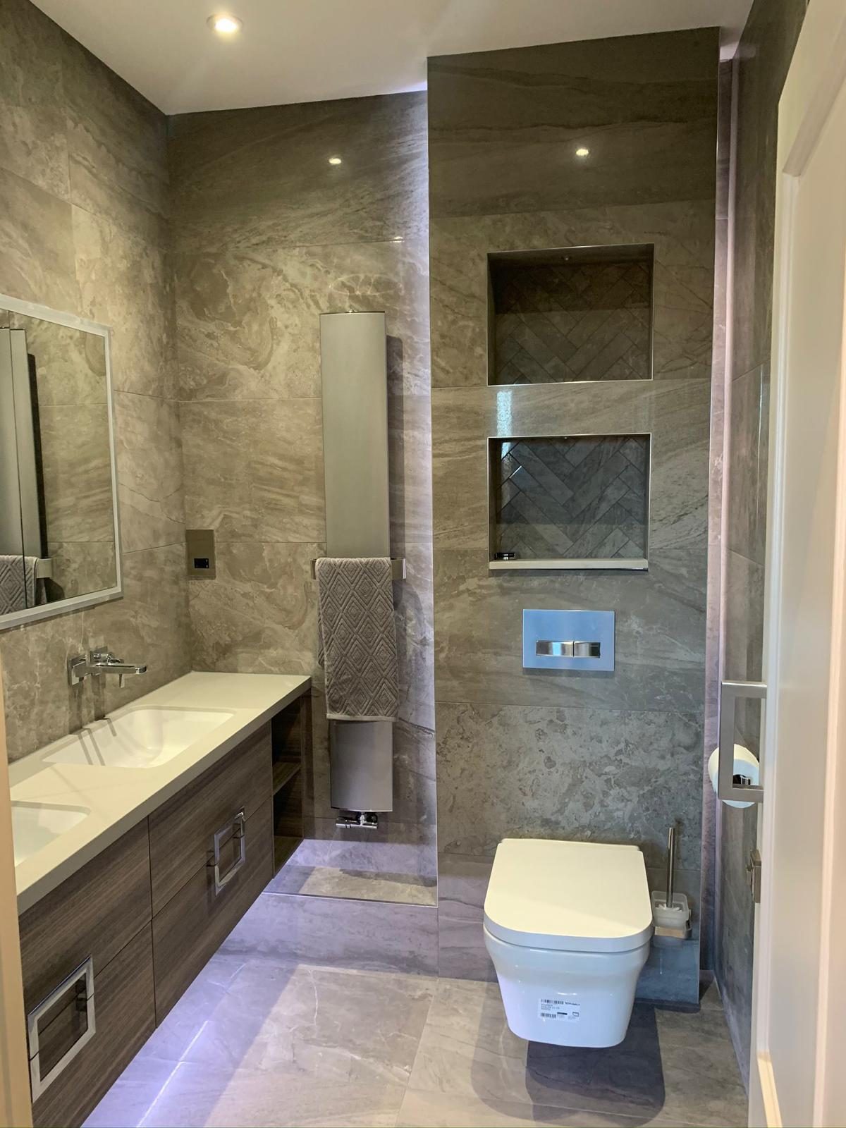 Completed bathroom suite with coordinated natural stone surfaces